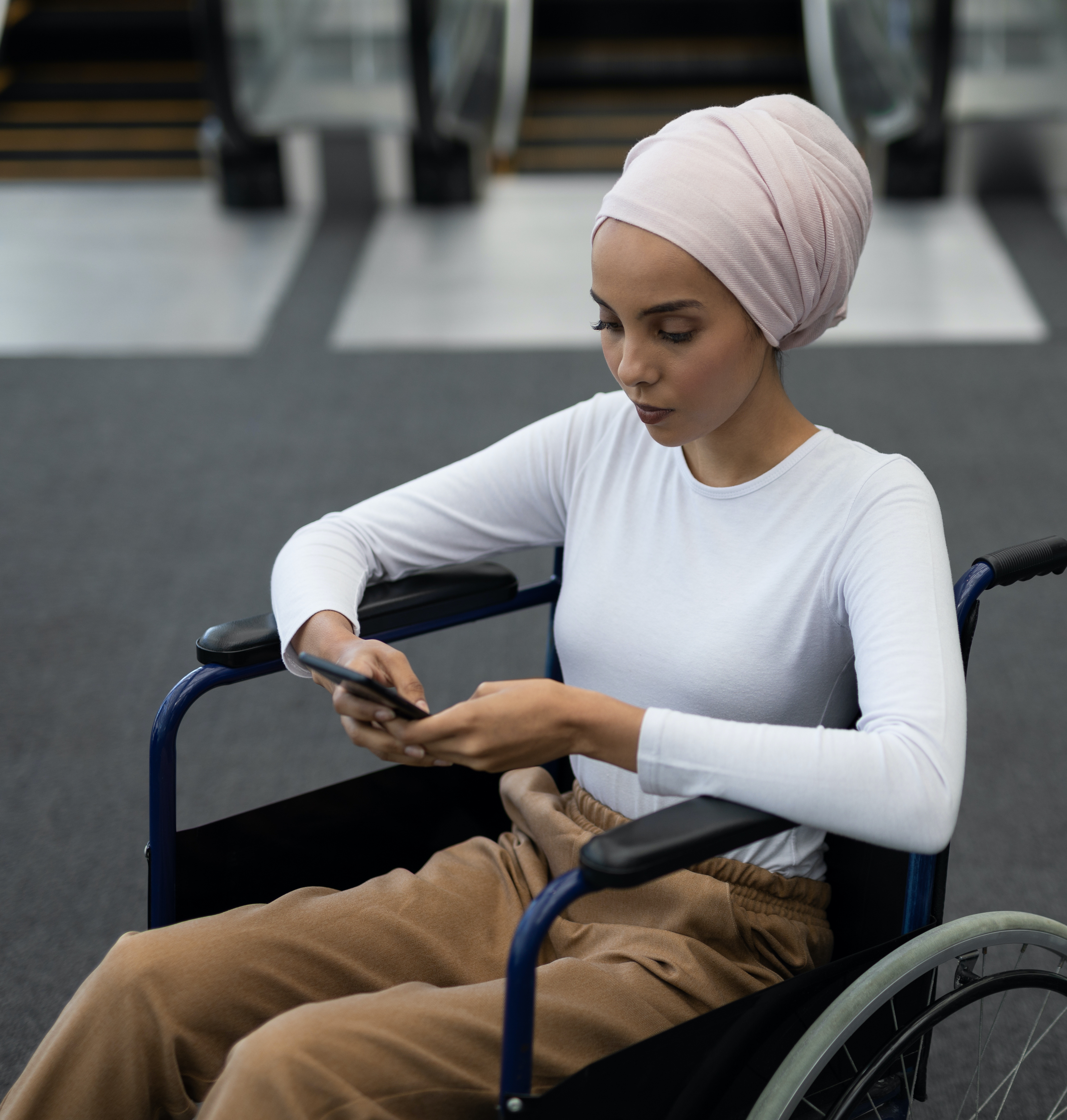 Woman in wheelchair checking phone