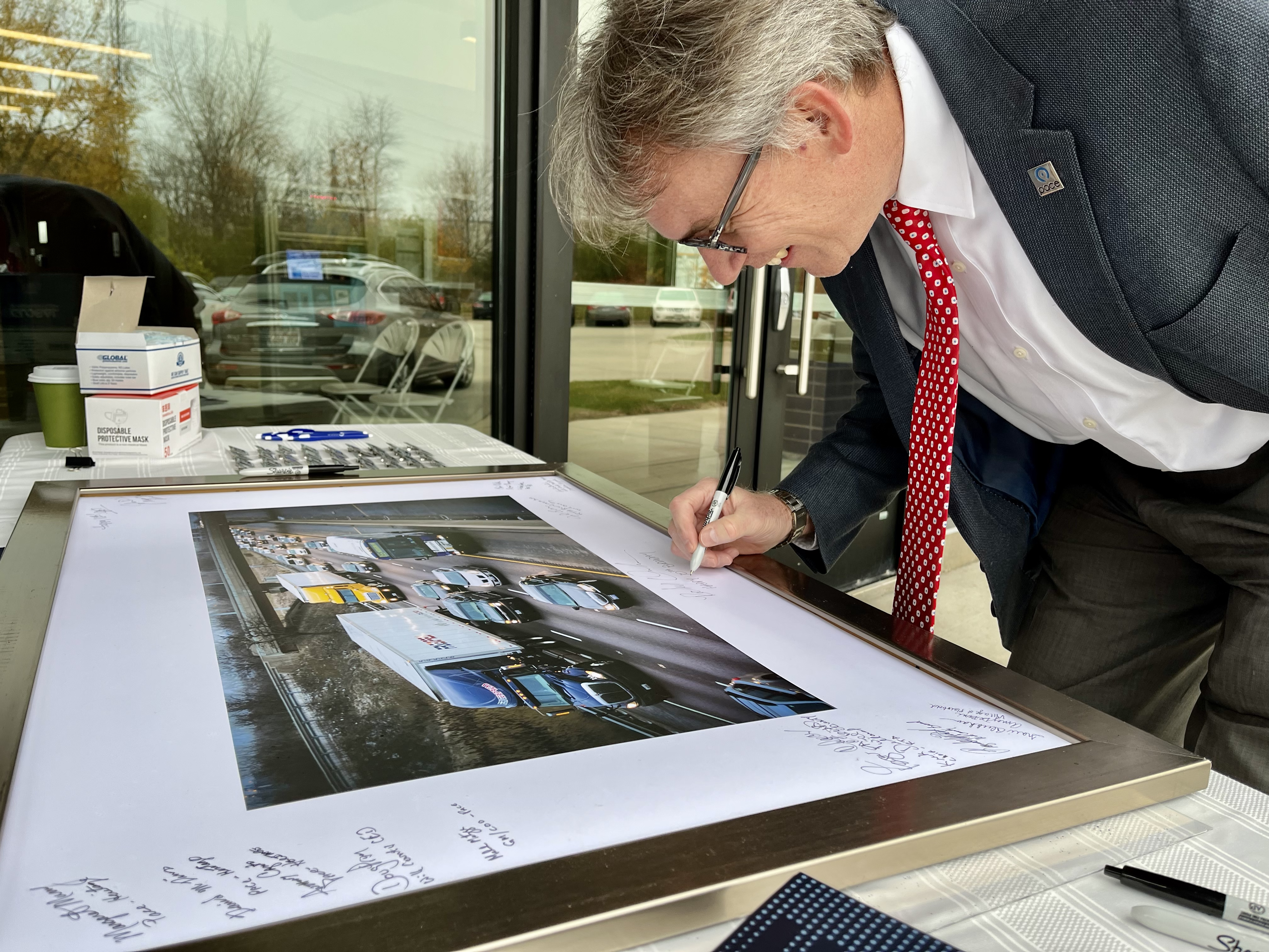 An image that shows Pace Executive Director Rocky Donahue signs commemorative