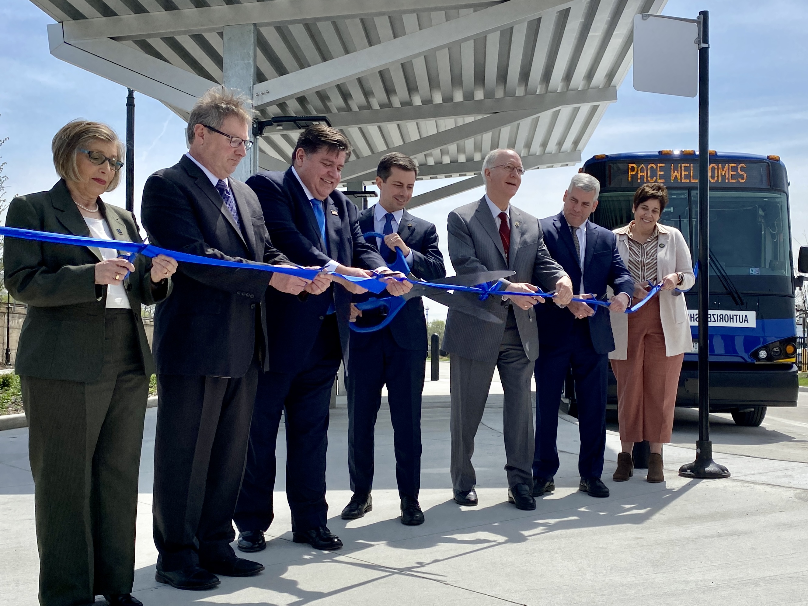 image showing Pace Executive Director Melinda J. Metzger, Pace Chairman Rick Kwasneski, Governor JB Pritzker, Transportation Secretary Pete Buttigieg, Congressman Bill Foster, Joliet Mayor Bob O’Dekirk, and Will County Executive Jennifer Bertino-Tarrant cut the ribbon on a new Pace Bus facility at the Joliet Gateway Center.