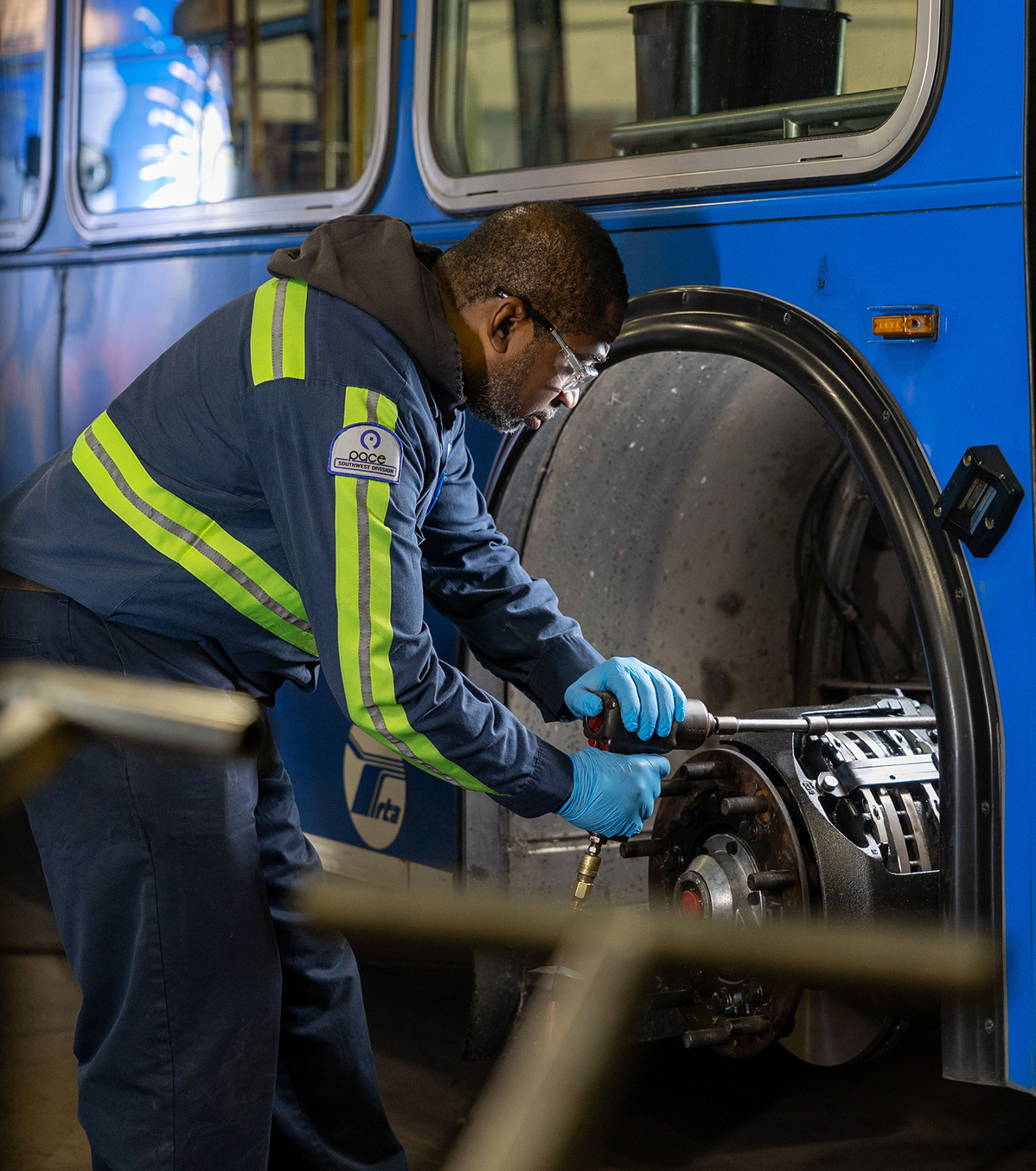Image of Pace bus mechanic doing a front axle brake job