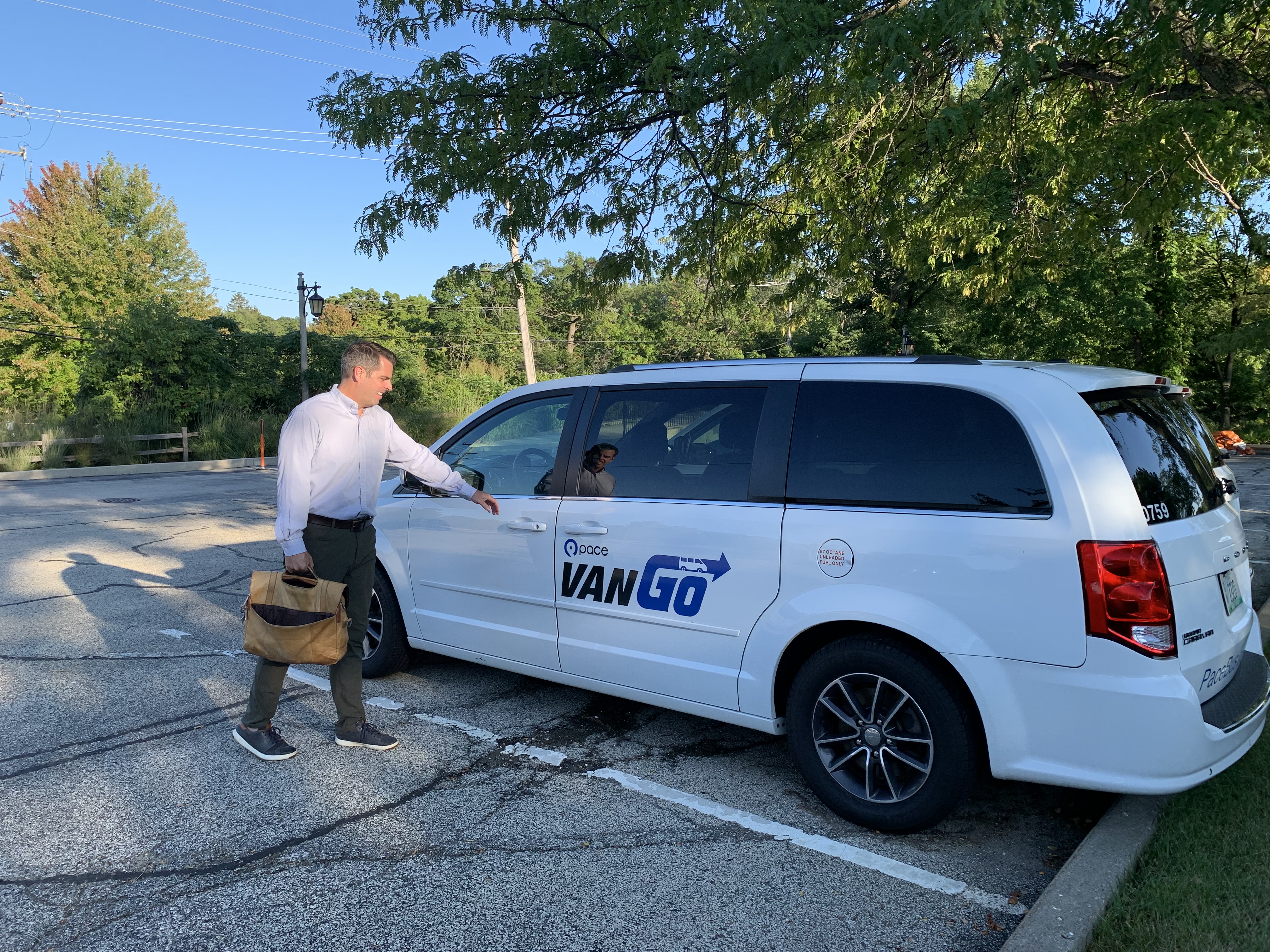 man with briefcase opening door of van with VanGo logo