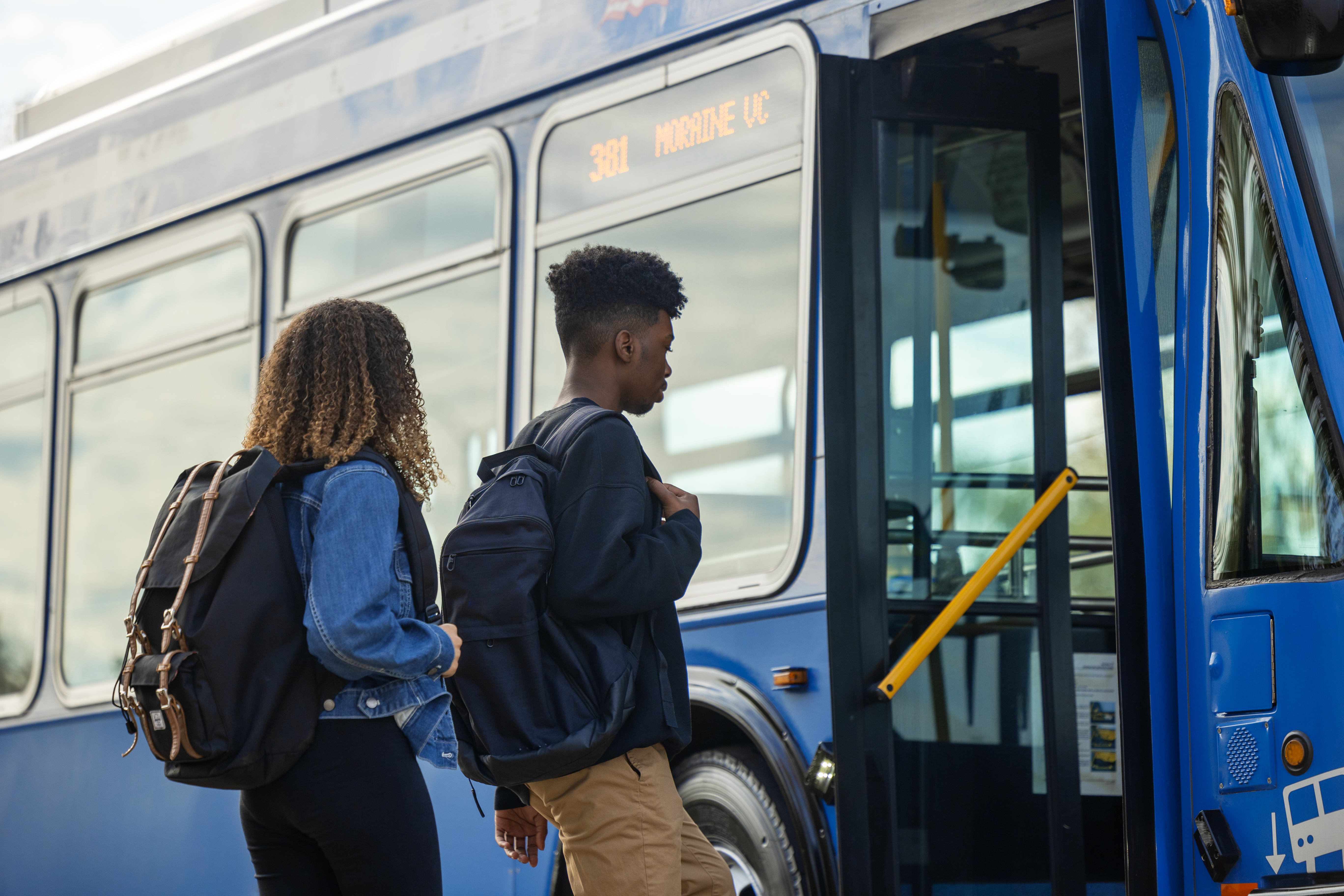 one female and one male student board a Pace bus