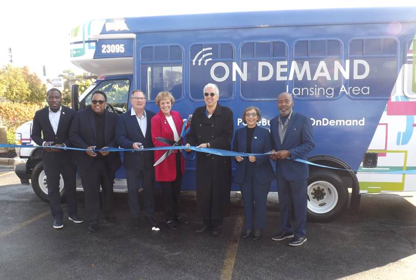 Photo of Pace and community leaders cutting a ribbon to celebrate the launch of the Lansing Area On Demand service