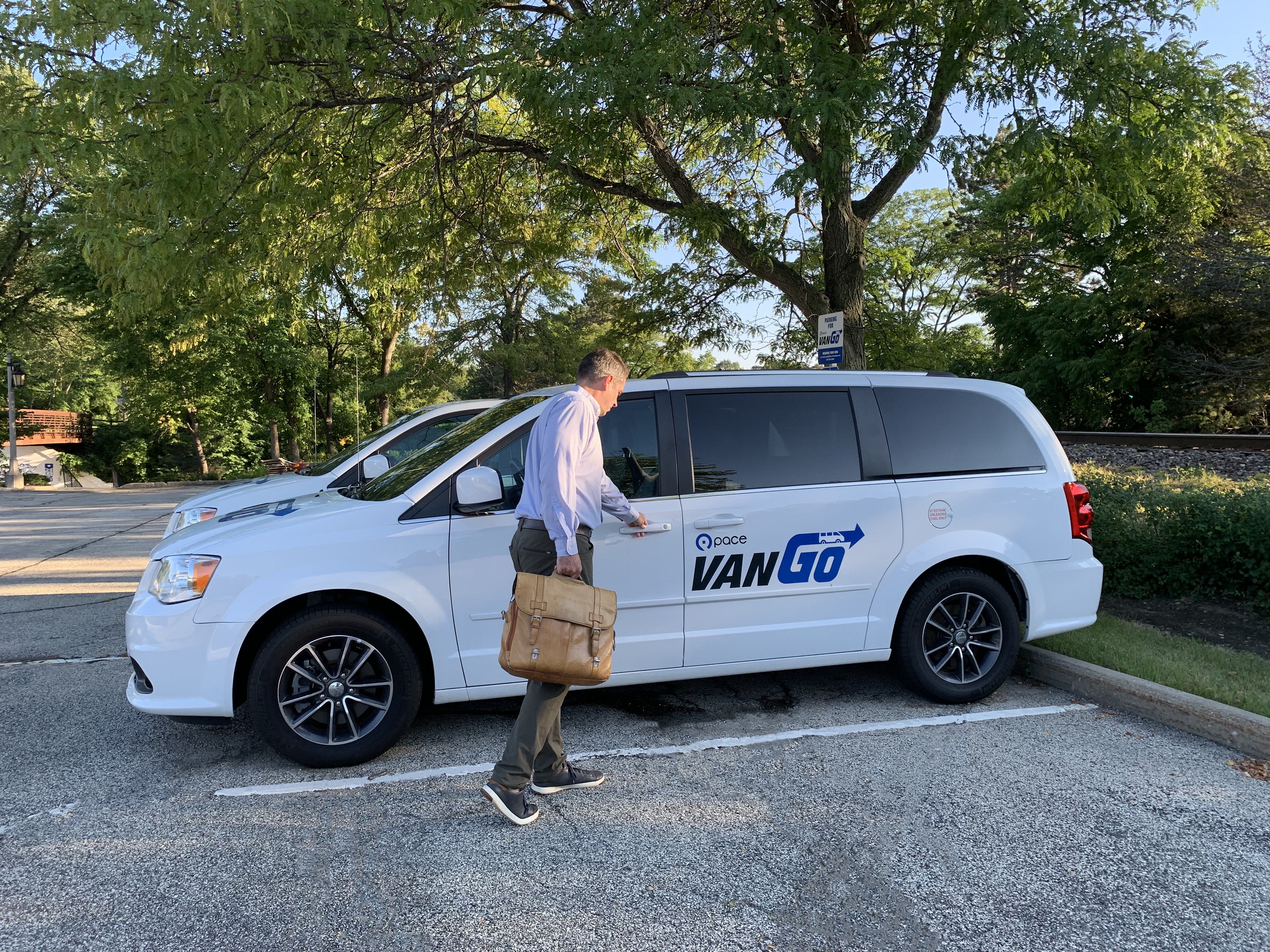 Male worker with briefcase enters Pace van with VanGo Logo