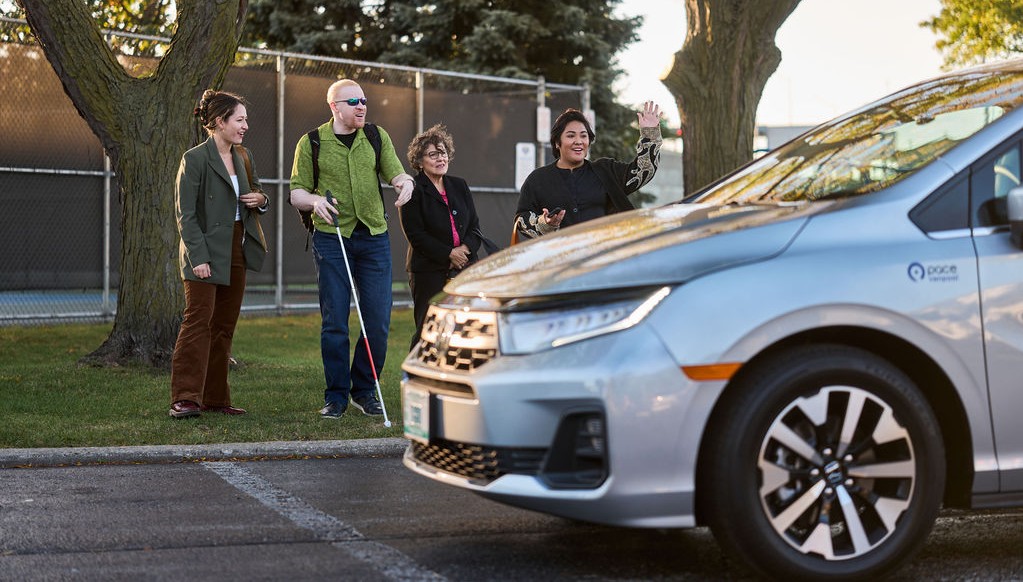Commuters standing together as a Pace van pulls up