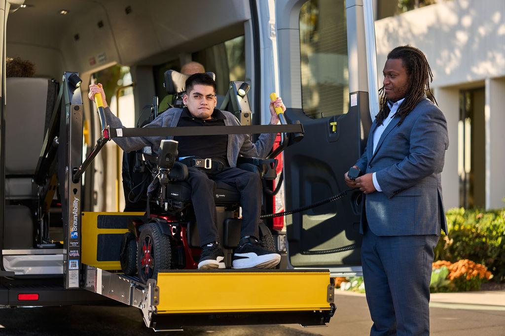 Vanpool driver helping the passenger use the lift at the back of the van