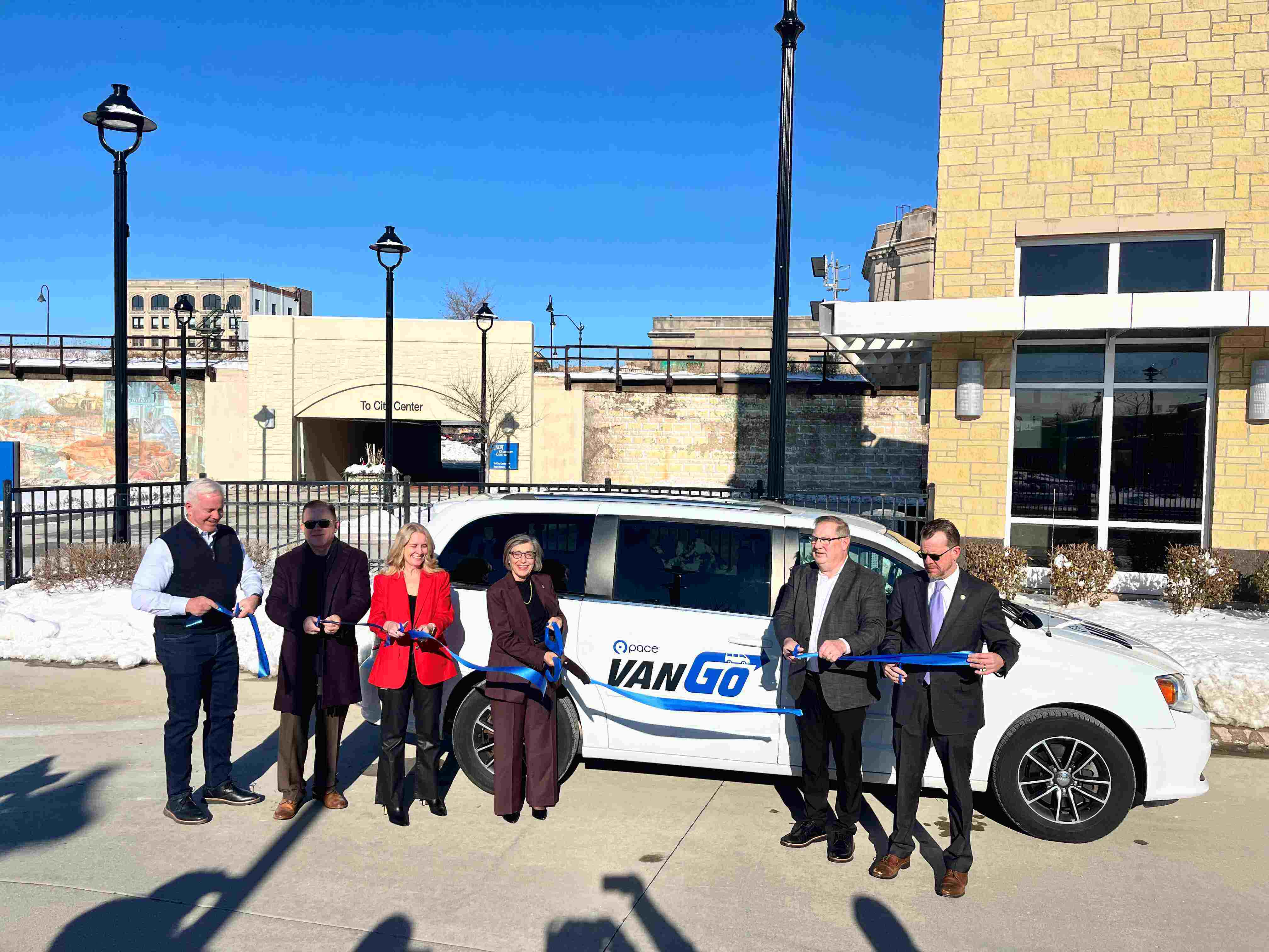 Photo of officials cutting a ribbon in from of a Pace VanGo van
