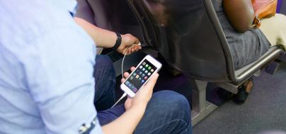 Image of a Pulse rider charging phone in the bus