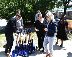 Image of event attendees standing by a stack of ground breaking shovels